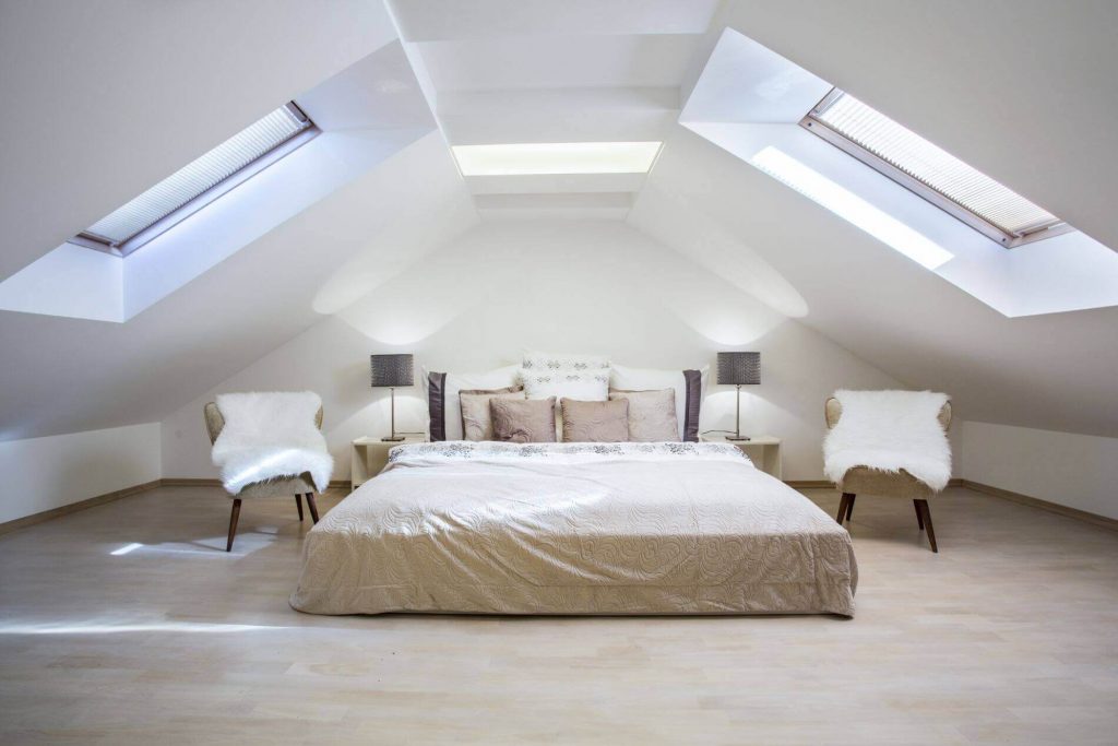 a double bed in a loft conversion bedroom with roof windows