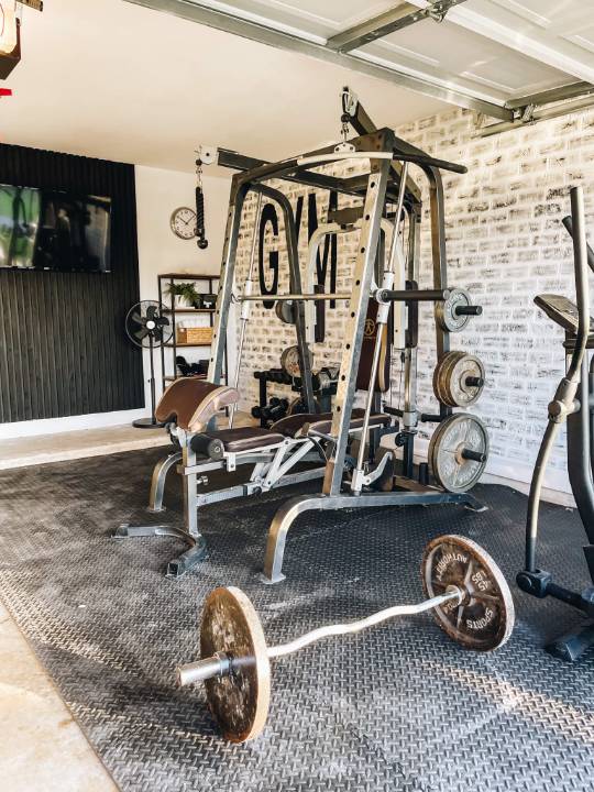 Transform your garage into a functional home gym in West Midlands/Birmingham. Featuring weight rack, squat machine, elliptical, and workout bench for fitness at home.